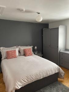 sypialnia z dużym białym łóżkiem z różowymi poduszkami w obiekcie Modern Apartment in Trendy Dalston w Londynie