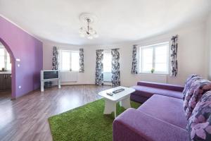 ein Wohnzimmer mit einem lila Sofa und einem TV in der Unterkunft Hostel Foster in Marienbad