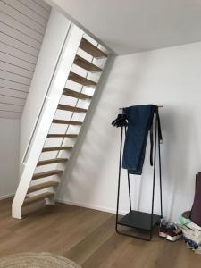 una habitación con una escalera y una camisa en un trípode en Appartement Velbruck, en Lieja