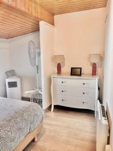 Ruelle-sur-Touvre的住宿－Jolie maison 2 chambres - CLIM MOBILE - TV - Proche d un lac，卧室配有白色的床和梳妆台。