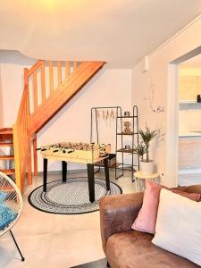 ein Wohnzimmer mit einer Tischtennisplatte und einer Treppe in der Unterkunft Jolie maison 2 chambres - CLIM MOBILE - TV - Proche d un lac in Ruelle-sur-Touvre