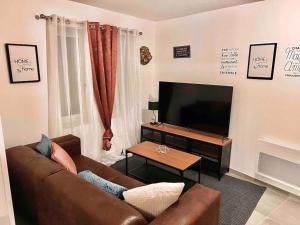 sala de estar con sofá y TV de pantalla plana en Jolie maison 2 chambres - CLIM MOBILE - TV - Proche d un lac en Ruelle-sur-Touvre