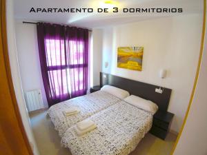 1 dormitorio con 1 cama con sábanas blancas y cortinas moradas en La PARRETA CENTRO, en Vinarós