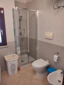 a bathroom with a shower and a toilet and a sink at Villa Cala Sinzias in Castiadas