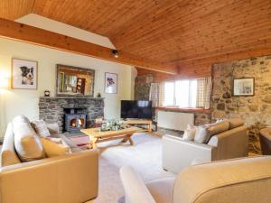 a living room with couches and a fireplace at Whiteside Cottage in Darvel