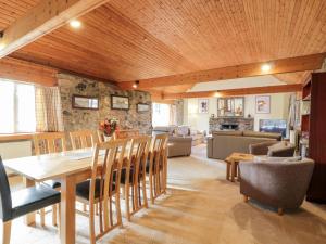 a dining room and living room with a table and chairs at Whiteside Cottage in Darvel