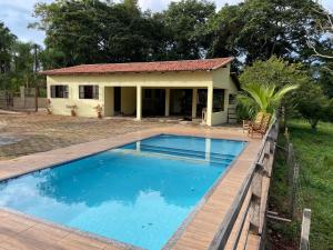 a house with a swimming pool in front of a house at Sítio Vovó Chiquinha - 4km Centro Histórico in Goiás