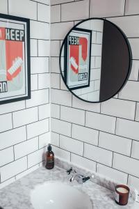 a bathroom with a sink and two mirrors at The Main Street Burrow - Your Perfect Hideaway in Saint Boswells