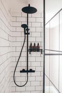 a bathroom with a shower with three jars at The Main Street Burrow - Your Perfect Hideaway in Saint Boswells