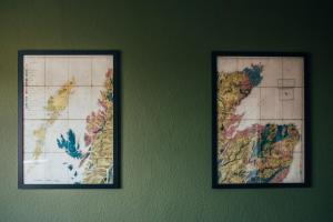 two framed maps hanging on a green wall at The Main Street Burrow - Your Perfect Hideaway in Saint Boswells
