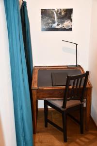 un escritorio de madera con una silla junto a una cortina azul en Hof-Fankhauser, en Wasen