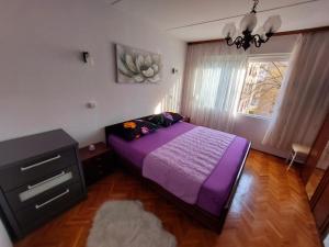 a bedroom with a purple bed and a window at Split apartment in Split