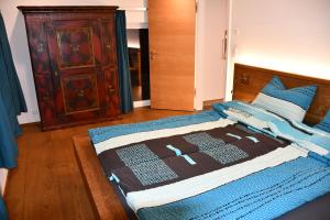 ein Schlafzimmer mit einem Bett mit einer blauen Decke darauf in der Unterkunft Hof-Fankhauser in Wasen