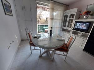a dining room with a table and chairs and a television at Split apartment in Split +21 photos