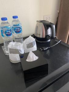 a counter with two bottles of water and a coffee maker at Tha-ruea Residence in Thalang
