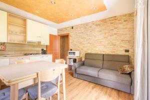 uma cozinha e sala de estar com um sofá e uma mesa em Casa Lucia em Ledro