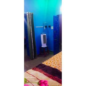 a room with a bed and a blue wall at Linga Homestay in Kanchipuram