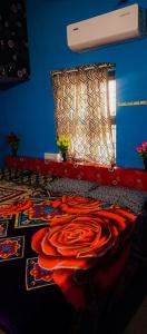 ein blaues Zimmer mit einer roten Decke auf dem Boden in der Unterkunft Linga Homestay in Kanchipuram