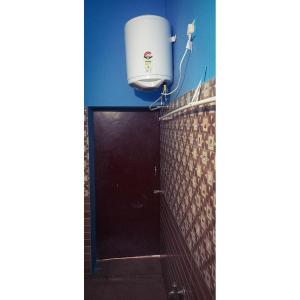 baño con puerta y depósito de agua en Linga Homestay, en Kanchipuram