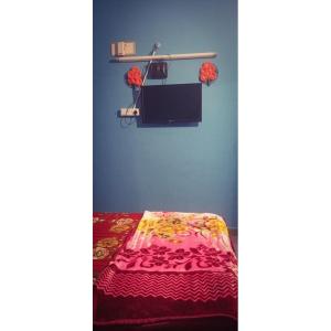 Zimmer mit einem Bett und einem Regal mit einer Decke in der Unterkunft Linga Homestay in Kanchipuram