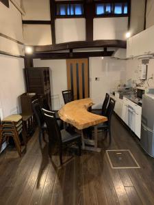 uma sala de jantar com uma mesa e cadeiras numa cozinha em Guesthouse Shin em Omihachiman