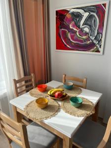 een witte tafel met fruitschalen erop bij Tirana Sunlight Apartment in Tirana