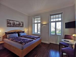a bedroom with a bed and a desk and window at Villa Deichvoigt in Cuxhaven