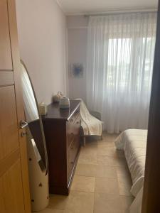 a bedroom with a dresser and a mirror and a bed at La casa di Flora aeroporto di Fiumicino in Fiumicino
