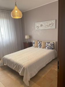 a bedroom with a large white bed with blue pillows at La casa di Flora aeroporto di Fiumicino in Fiumicino