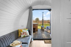 a living room with a couch and a sliding glass door at Kingston Black, Apple Tree Glamping, Nr Wells in Wells