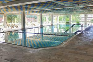 a swimming pool with chairs in a building at RELAX - BLUE mit Pool und Sauna in Scheidegg