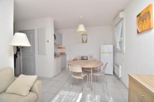 a kitchen and dining room with a table and chairs at T2 Résidence Cap Camargue avec piscine in Le Grau-du-Roi