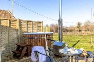 a wooden deck with a wooden barrel and a table and a table at Kingston Black, Apple Tree Glamping, Nr Wells in Wells