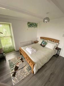 a bedroom with a large bed and a rug at Woodlands Bellevue Bed & Breakfast in New Quay