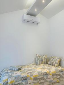 a bed in a room with a white wall at Studio apartment MAR 1 in Dubrovnik