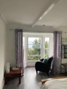 Woodlands Bellevue Bed & Breakfast في نيو كي: غرفة معيشة مع أريكة ونافذة