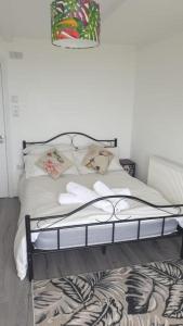 Woodlands Bellevue Bed & Breakfast في نيو كي: غرفة نوم عليها سرير وفوط بيضاء