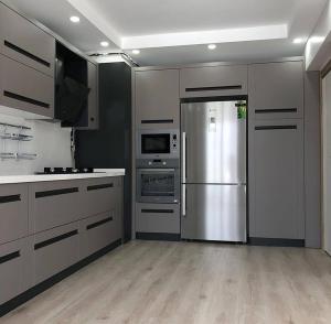 una cocina con nevera y electrodomésticos de acero inoxidable en Erzurum DAMAK GRUP en Erzurum