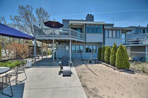 een huis met een patio met een terras en een parasol bij Lakefront Family Retreat with Grill Steps to Beach! in Gary