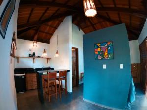uma cozinha com uma parede azul com uma pintura em Bangalô Patuá em Barra Grande