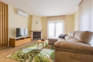 Una sala de estar con un sofá y un televisor. en Vila da Serra, en São Mamede