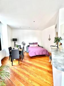 a bedroom with a bed and a table and chairs at HYPER CENTRE - Colmar Cathédrale - PARKING Gratuit in Colmar