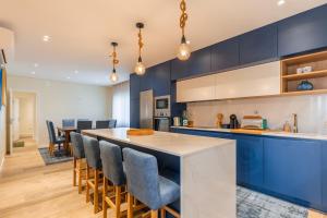 una cucina con armadi blu e un bar con sedie di Vila da Serra 