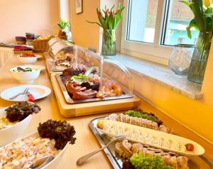 a buffet with several trays of food on a table at Hotelpark Bodetal mit Ferienwohnungen in Thale