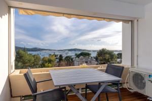 a dining room with a table and chairs and a large window at Studio avec vue mer et terrasse in La Seyne-sur-Mer