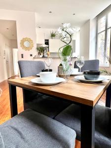 a dining room table with two chairs and a table with glasses at HYPER CENTRE - Colmar Cathédrale - PARKING Gratuit in Colmar