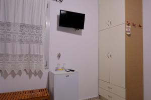 um quarto branco com uma televisão na parede em Giasemi Room No 7 Irakleia em Livadi Astypalaias