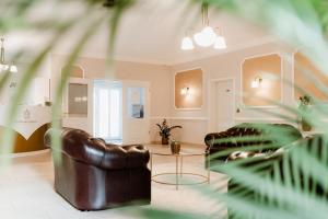 a living room with two leather chairs and a table at Hotelpark Bodetal mit Ferienwohnungen in Thale