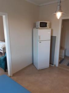 a kitchen with a microwave on top of a refrigerator at Willa Witsari 35m2 asunto in Kokkola