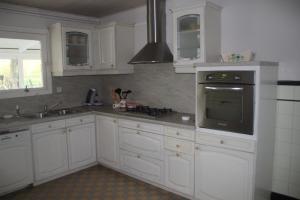 a kitchen with white cabinets and a stove top oven at gite du lincret in Frencq +5 photos